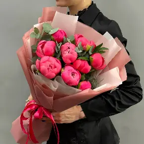 Букет из 9 коралловых пионов с эвкалиптом в двухслойной упаковке в Москве