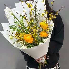 Весенний букет с желтыми ранункулюсами и цветущими ветками форзиции в Москве