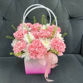 Композиция их гвоздик и тласпи в сумочке  в Москве