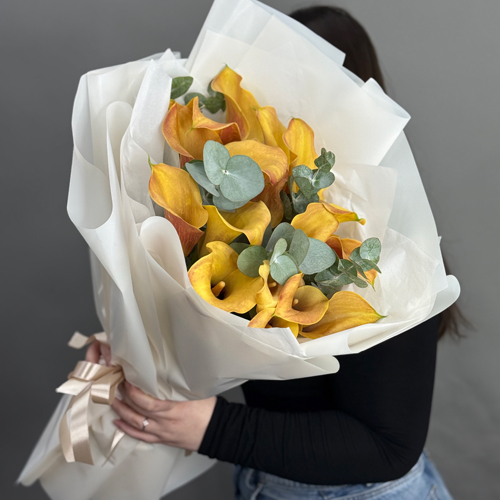 Букет из 17 оранжевых калл с эвкалиптом в Москве Букет из 17 оранжевых калл с эвкалиптом в Москве